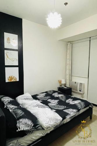 a bedroom with a bed with black and white sheets at Azure Urban Resort near NAIA Airport in Manila