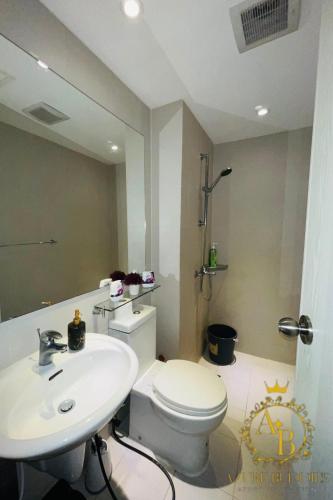 a bathroom with a white toilet and a sink at Azure Urban Resort near NAIA Airport in Manila
