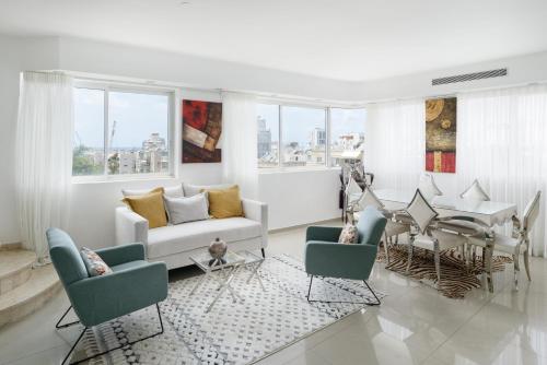 uma sala de estar com um sofá e uma mesa em Penthouse with Panoramic View by FeelHome em Tel Aviv