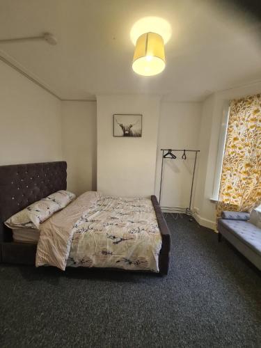 a bedroom with a bed and a window and a couch at Double Rooms with shared bathroom in Gillingham