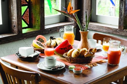 un tavolo con colazione a base di frutta e succhi di Rancho Cipo Pousada a Serra do Cipo