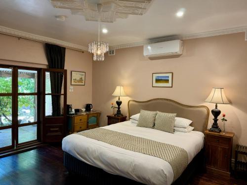 um quarto com uma cama grande e um lustre em Jacobs Creek Retreat - Barossa Valley em Tanunda