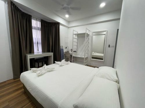 a bedroom with a large white bed and a mirror at Genting View Resort in Genting Highlands