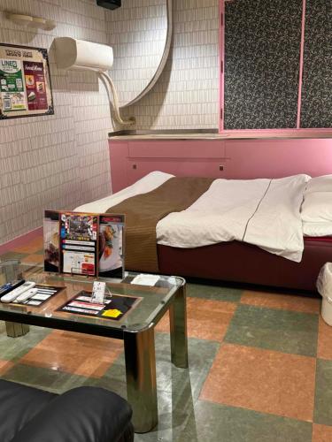Zimmer mit einem Bett und einem Tisch mit einem Couchtisch in der Unterkunft STYLISH in Kōbe