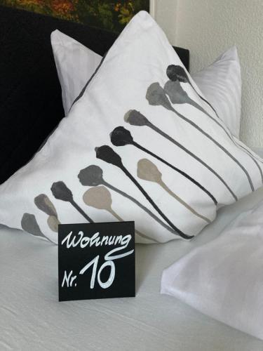 a sign sitting on top of a bed with pillows at Haus Brandenburg in Stechlin
