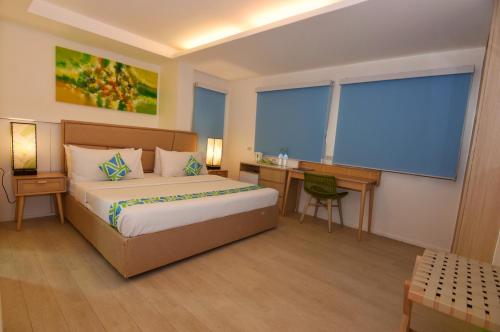 a hotel room with a bed and a desk and a window at Lime Hotel Boracay in Boracay