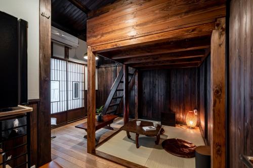 Habitación con cama elevada y paredes de madera. en すずめや築地, en Tokio