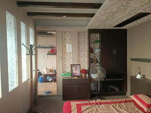 a bedroom with a bed and a room with a fan at 1bhk in Pātan