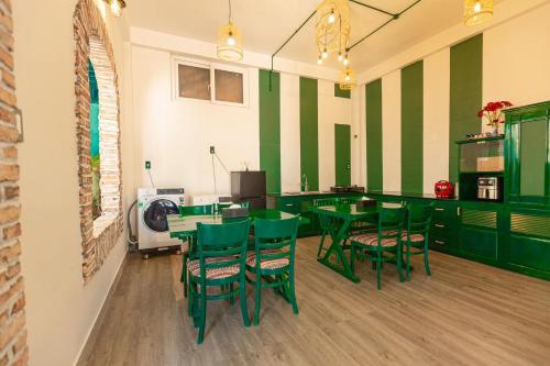 un comedor con sillas y mesas verdes en Homestay Tháng 5, en Da Lat