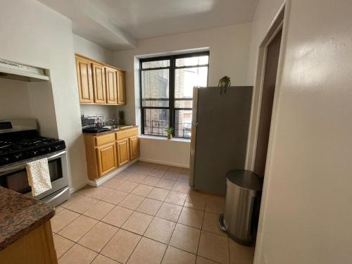 a kitchen with a stainless steel refrigerator and a window at Comfy Guest House by Columbus Circle in New York