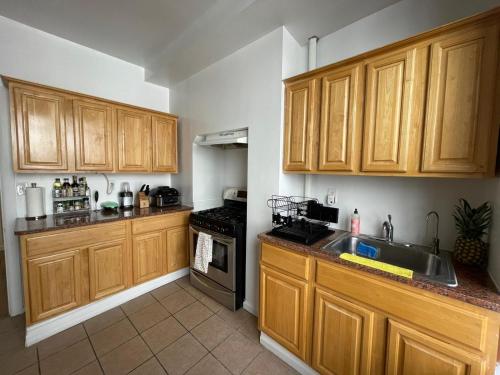 a kitchen with wooden cabinets and a sink at Comfy Guest House by Columbus Circle in New York