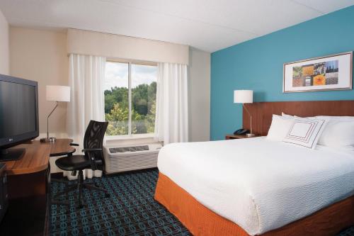 ein Hotelzimmer mit einem Bett, einem Schreibtisch und einem TV in der Unterkunft Fairfield Inn Greenville Spartanburg Airport in Greenville