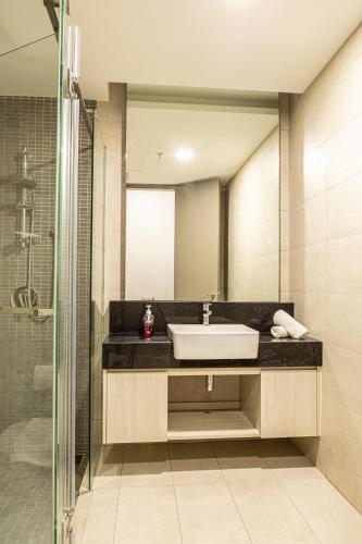 a bathroom with a sink and a shower at Societe Suites By iHost Global in Kuala Lumpur