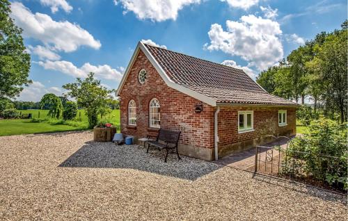 a small brick house with a bench in a yard at Kruudhuuske in Aalten