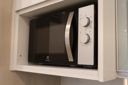 a microwave oven in a kitchen with its door open at Societe Suites By iHost Global in Kuala Lumpur