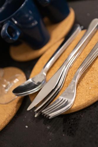 two silver forks sitting on top of a cutting board at Societe Suites By iHost Global in Kuala Lumpur