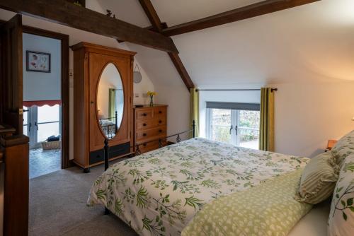 a bedroom with a bed and a dresser and a mirror at Crooks in Axbridge