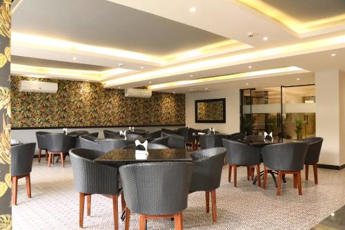 a restaurant with tables and chairs in a room at Ahuja Residency Mayfield Garden in Gurgaon