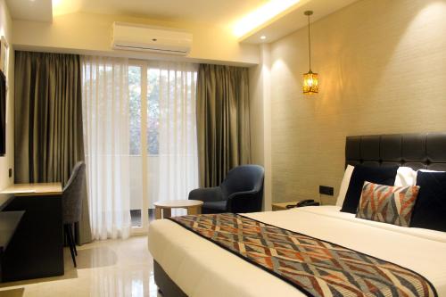 a hotel room with a bed and a window at Ahuja Residency Mayfield Garden in Gurgaon