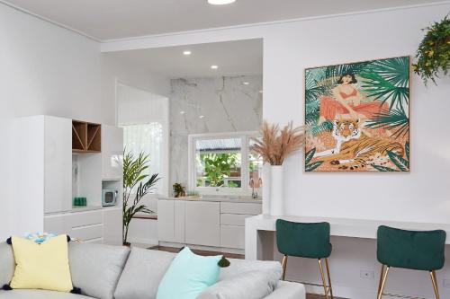 a living room with a couch and a kitchen at The Queenslander! Complete Entertainer - Huge - Stylish - Games - Full Level Pool Room - Smokehouse - Secure Parking - Yard #NEW! in Gold Coast