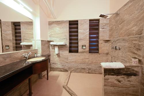 un bagno con lavandino e doccia di WelcomHeritage Taragarh Palace a Kangra