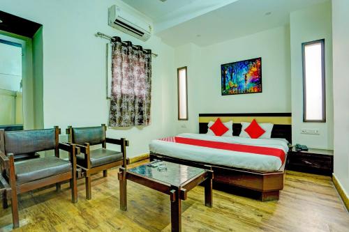 1 dormitorio con 1 cama, 1 silla y 1 mesa en Super OYO Hotel Sunshin Deluxe, en Nagpur
