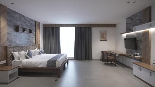 a bedroom with a bed and a desk and a television at RITZ AVENUE LUXURY HOTEL in Mahe