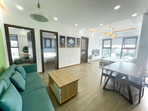 ニャチャンにあるRoyal Nha Trang Luxury Apartmentの緑のソファとテーブルのあるリビングルーム