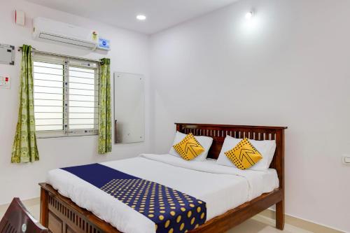 een slaapkamer met een bed met gele en blauwe kussens bij Hotel Hills Land in Warangal
