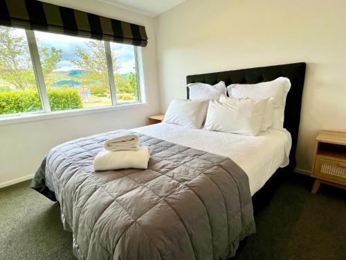 a bedroom with a large bed with two towels on it at Large and Luxurious at the Lake in Kinloch