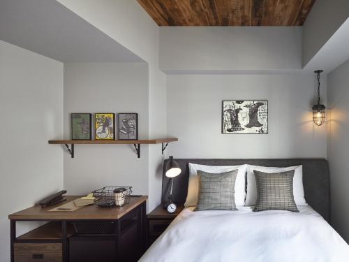 a bedroom with a bed and a desk at Hotel Resol Akihabara in Tokyo