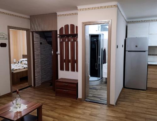 una habitación con espejo y una habitación con cocina en Csillag Vendégház Kiskunmajsa en Kiskunmajsa