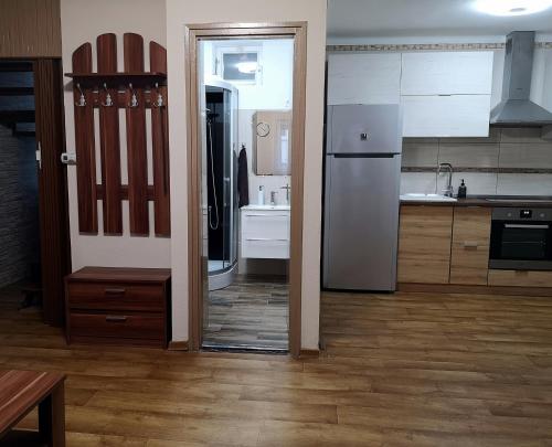 a kitchen with a refrigerator and a sink at Csillag Vendégház Kiskunmajsa in Kiskunmajsa
