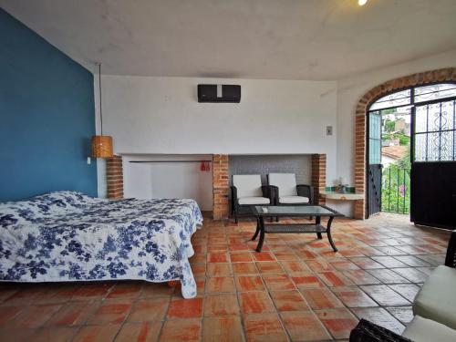 a bedroom with a bed and a table and a couch at Casa Rey Sol Vallarta in Puerto Vallarta