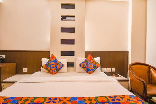 a bedroom with a bed with colorful pillows on it at FabHotel Emerald in Rānchī