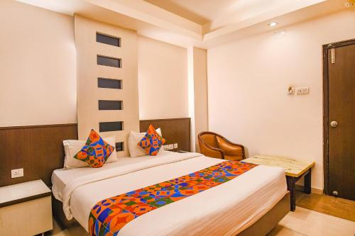 a bedroom with a large bed with colorful pillows at FabHotel Emerald in Rānchī