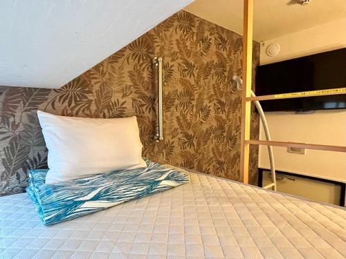 a bed with a pillow on it in a bedroom at HOTEL StoRK Naha Shintoshin - Vacation STAY 27620v in Naha