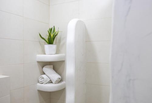 ein Badezimmer mit einem WC mit einer Pflanze darauf in der Unterkunft White wave studio 1 , 3min walk from Kamari beach in Kamari