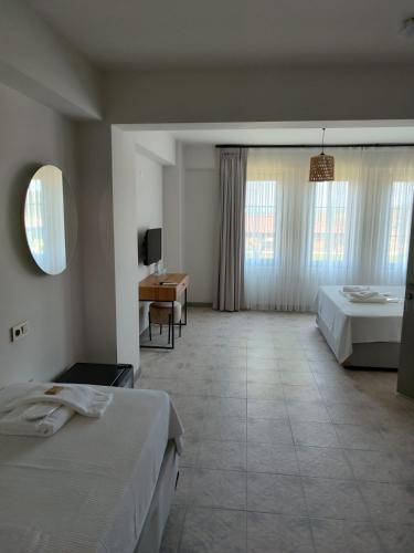een hotelkamer met 2 bedden en een badkamer bij Thalassa Hotel Bozcaada in Bozcaada
