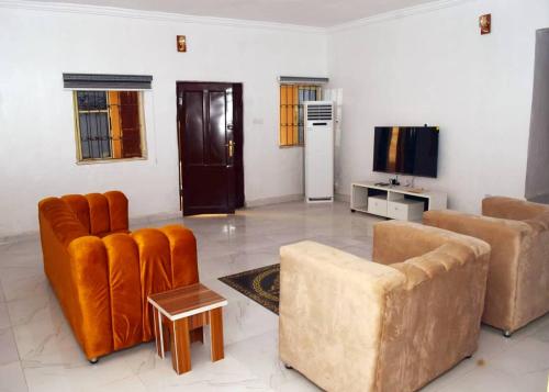a living room with two couches and a tv at T'S PLACE APARTMENT in Abeokuta