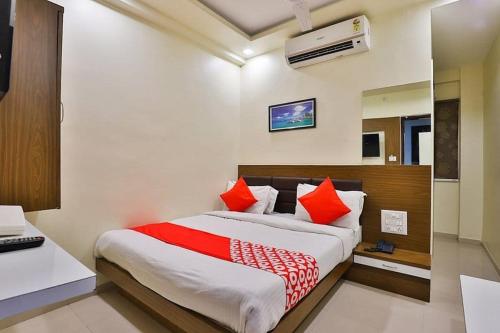 um quarto com uma cama grande e almofadas vermelhas em HOTEL KHUSHBOO em Ahmedabad