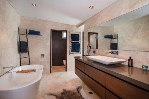 ein großes Bad mit einer Badewanne und einem Waschbecken in der Unterkunft Oceana - sweeping ocean views, short walk to beach in Gracetown