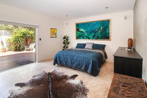 ein Schlafzimmer mit einem Bett und einem großen Wandgemälde in der Unterkunft Oceana - sweeping ocean views, short walk to beach in Gracetown