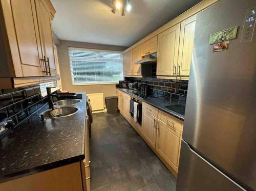 a large kitchen with a stainless steel refrigerator at Luxury 3 bed coastal house in North Tyneside