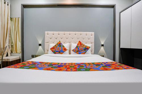 ein Schlafzimmer mit einem großen weißen Bett mit bunter Bettwäsche in der Unterkunft FabHotel Grand Inn II in Navi Mumbai