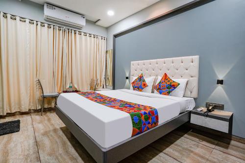 ein Schlafzimmer mit einem großen Bett in einem Zimmer in der Unterkunft FabHotel Grand Inn II in Navi Mumbai