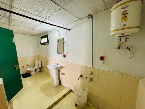 a bathroom with a toilet and a sink at Room on the Roof, Viraatkhai-Chakrata, By Himalayan Eco Lodges in Chakrāta