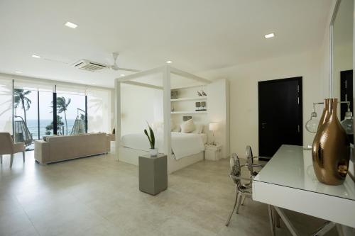 een witte woonkamer met een bed en een bank bij Green Turtle Villa by The Serendipity Collection in Bentota