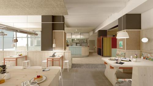 a kitchen with tables and chairs in a room at MEININGER Hotel München Zentrum in Munich