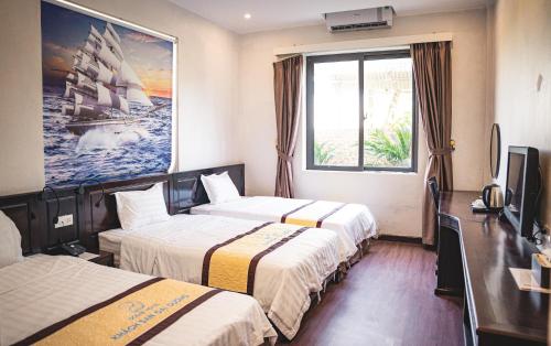 a hotel room with two beds and a tv at Khách sạn Đại Dương Diễn Châu - Nghệ An in Diễn Châu